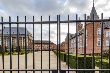 Arka planda 16. yüzyıldan kalma Alden Biesen şatosu, pencereler ve tuğla duvarlar, Bilzen, Limburg, Belçika 'da bulutlu bir gün