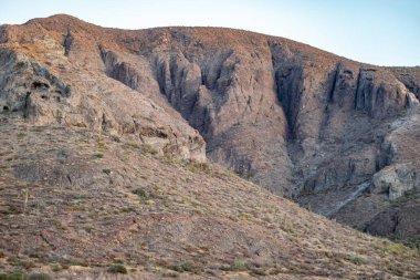 Gün batımında mavi gökyüzüne karşı kayalık çöl manzarası bozkır arazisi, Baja California Sur, Meksika 'da seyrek yabani ot ve bitki örtüsü.