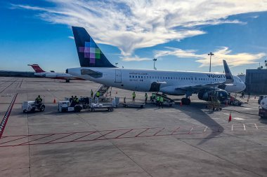 La Paz, Baja California Sur Mexico. 9 Şubat 2023. Yolcuların, işçilerin ve ekipmanların binmesini ya da inmesini kolaylaştırmak için önlüklü Volaris uçağı mavi gökyüzü ile güneşli bir gün.