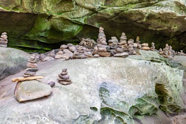 Cairns ya da apachites olarak bilinen dev kaya yığınları, arka planda yosun olan kaya oluşumu, Teufelsschlucht doğa koruma alanında güneşli bir gün, Irrel, Almanya