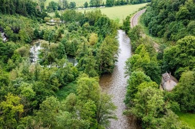 Logne Kalesi 'nden görünen, bol yeşil yapraklı ağaçların arasından akan bol suyla Ourthe Nehri, Belçika, Ferrieres' de bulutlu bir gün.