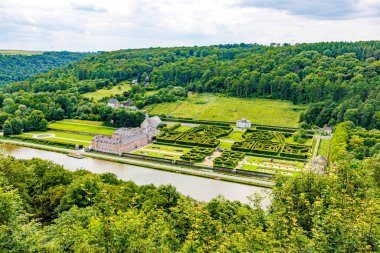 Aerial view of valley with Freyr castle in Renaissance style, French style gardens, Meuse river and hill with leafy trees in background, cloudy summer day in Namur province, Wallonia, Belgium clipart