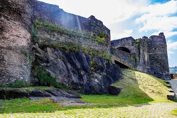 La Roche-en-Ardenne şatosu kayalık tepede yıkıntılar, zamanın aşındırdığı taş duvarlar, Çakıl taşı yolu, Belçika 'da mavi gökyüzü ile güneşli bir gün.