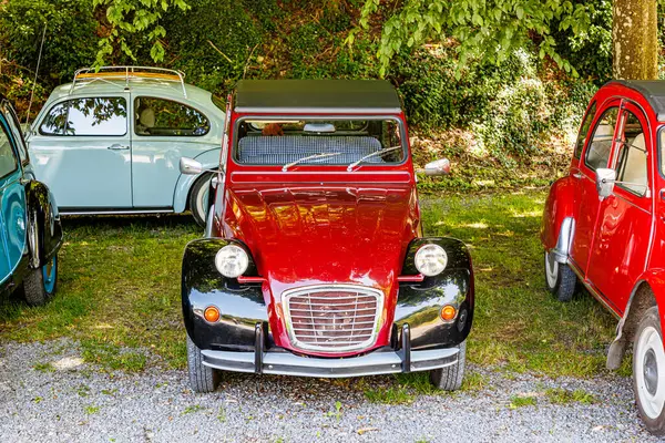 stock image Well preserved vintage car with red bodywork among group of old convertible luxury cars with soft top, rearview mirror, headlights, chrome metal details, sunny summer day in Belgium