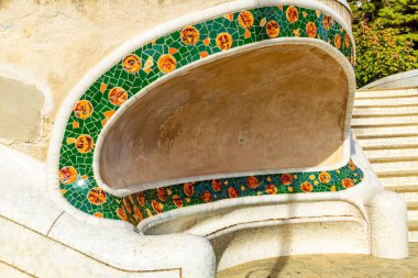 Sarı dokunuşlu yeşil kiremitli oval yapı, sürreal stil ve şekiller, Antoni Gaudi 'nin Parc Guell' i, Barselona, Katalonya, İspanya 'da güneşli bir gün.