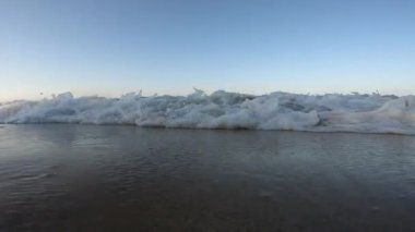 Sahilde kameraya karşı kırılan dalgaların yakın çekim görüntüleri Pasifik Okyanusu 'ndan sakin bir şekilde akan sular Nuevo Vallarta, Nayarit, Meksika' da kış sabahı