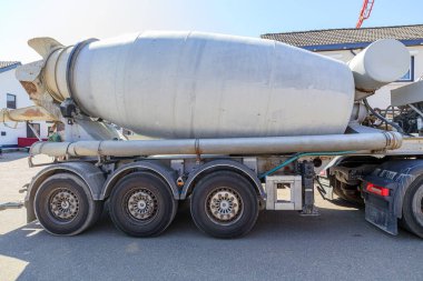 Beton karıştırma tankı, köy sokağı, tekerlekler, hortumlar, temizlik sistemi ve elektrikli ekipman, Gulpen, Güney Limburg, Hollanda 'da güneşli gün