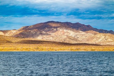 Meksika kıyı şeridi, plaj, çayır ve dağ sıraları mavi gökyüzü, kuru ve sarımsı yabani otlar, Baja California Sur 'da Loreto, Meksika