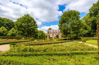 TerWorm Kalesi 'ndeki halka açık parktaki çalılar ve çiçek açan bitkiler, arka planda duran yeşil yapraklı ağaçlar ve şato, Heerlen, Güney Limburg, Hollanda' da güneşli bir yaz günü