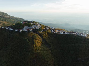 Gün batımında dağın zirvesine bakan bir park alanı, ziyaretçilere aşağıdaki vadinin nefes kesen panoramik manzarasını sunuyor..