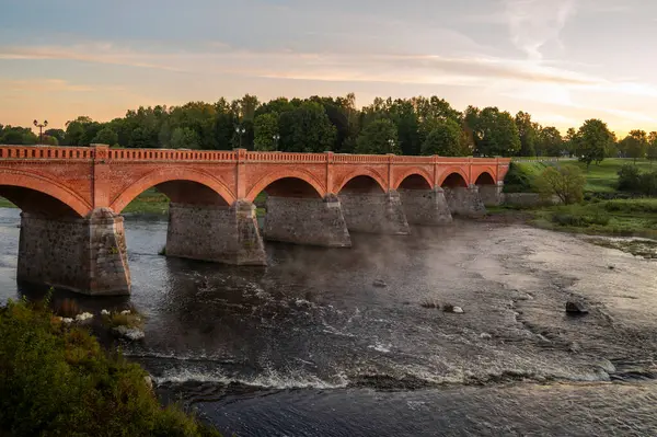 秋天日出时分 拉脱维亚库尔迪纳 Venta河上的石桥 紧邻欧洲最大的瀑布 Ventas Rumba 图库照片
