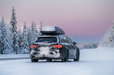 Kışın Laponya. Renkli günbatımında çok kar yağar.