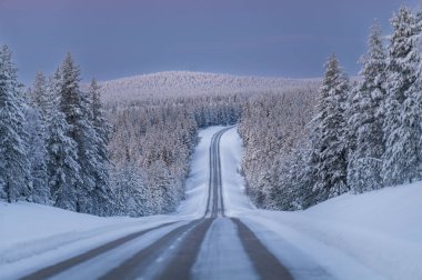 Kışın Laponya. Renkli günbatımında çok kar yağar.