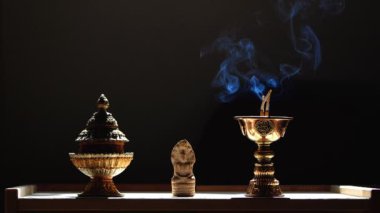 Yanan bir çubuktan çıkan mavi duman Buda tapınağında yavaşça yükselir tütsü tutacağıyla siyah arka planda