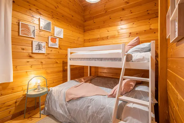 Children bedroom with bunk bed and wooden walls. Cozy and comfortable cottage interior
