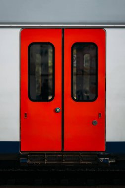 Bir elektrikli tren vagonunun sürgülü kapılarını açmak için modern teknolojiler. Metro treninin bir parçası olarak bir yolcu vagonunun kapalı kırmızı kapıları. Hızlı yolculuk için bir araç