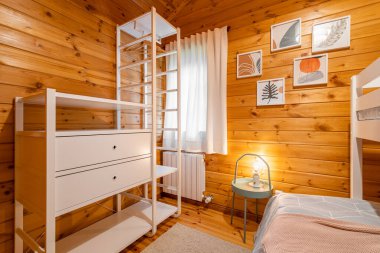 Yatak odası, ranza, gardırop ve ahşap duvarlar. Konforlu ve rahat bir kulübe.