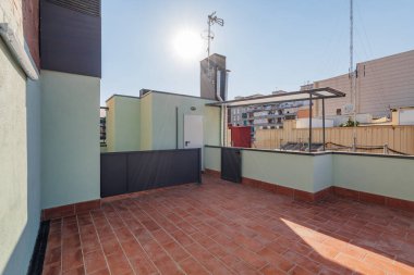 Kırmızı döşemesi olan bir çatıda açık teras. Manzaranın tadını çıkarmak ve gün batımını izlemek için harika bir yer.