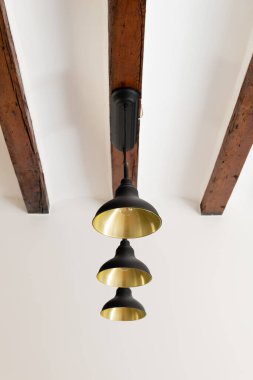 Eski ahşap tavan kirişine bağlı ampullü metal avize. İç tasarımda ev ışığı ekipmanı. Dekorun klasik ögesi