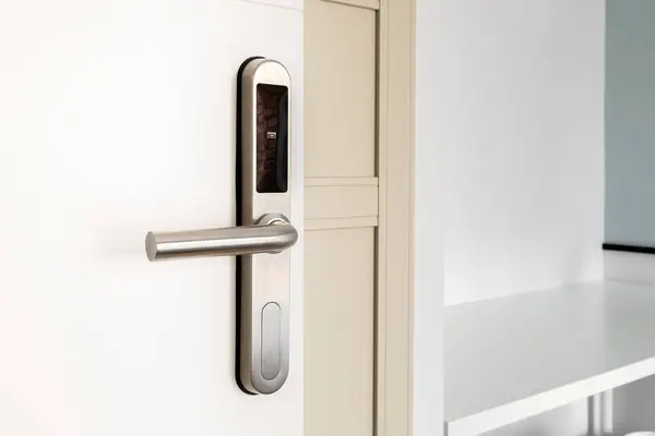 Open front door with electronic mortise lock and handle. The door is opened with a combination of a digital code or a plastic card. Modern door opening and property security systems