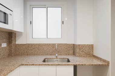 Modern mutfak kaygan kuşak penceresinden gün ışığıyla aydınlanır. Siyah benekli bej granit duvarlar. Mutfak mobilyaları beyaz parlak boyayla kaplı ahşaptan yapılmış. Dahili modern teknoloji.