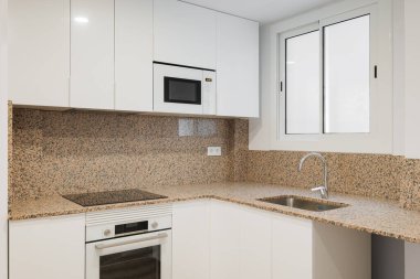 Modern mutfak kaygan kuşak penceresinden gün ışığıyla aydınlanır. Siyah benekli bej granit duvarlar. Mutfak mobilyaları beyaz parlak boyayla kaplı ahşaptan yapılmış. Dahili modern teknoloji.