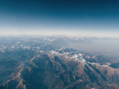 Karla kaplı Alpler 'in inanılmaz güzel panoramik hava manzarası. Karla kaplı Alp dağlarının tepelerinden uçmak. Gök mavisi ile ufuktan ufka dağ aralığı
