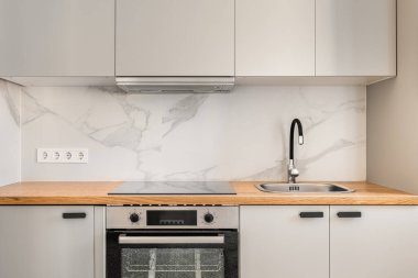 Mutfağın gri katı renklerde, yeni bir dairede rahat duvar dolapları ve modern aletleri olan bir parçası. Önceki sahiplerinden sonra yenileme konsepti. Kopyalama alanı.