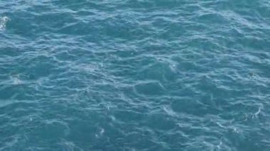 Güneşli ve sıcak bir yaz gününde, tropik bir ülkede dolaşırken, hareketli dalgalarla açık mavi bir deniz manzarası. Aktif eğlence ya da tatil konsepti. Kopyalama alanı.