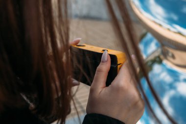 Lihtenştayn 'da, birisi sarı bir kamera kullanarak yansımaları yakalıyor, manzaranın güzelliğini vurguluyor.