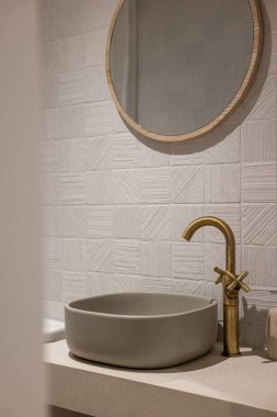 Bu çağdaş banyo düzeneği şık dekoratif elementlerle eşleştirilmiş şık bir minimalist leğen sergiliyor.