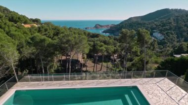 Muhteşem bir kıyı manzarası güzel Costa Brava 'yı sergiliyor, yemyeşil bir havuzun ortasında lüks bir havuz var.