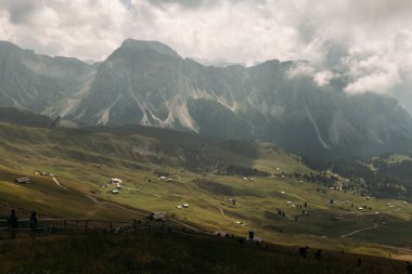 Experience the breathtaking view of the stunning Dolomites mountains, with their lush valleys and moody skies clipart