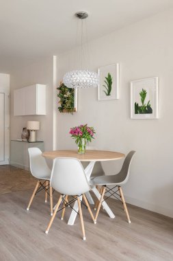 Yuvarlak yemek masası, konsol ve dekoratif aksesuarları olan modern tarz oturma odası. Beş yıldızlı bir otelde otel konsepti..