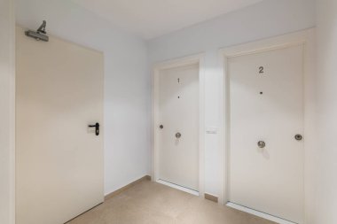İki giriş kapısı olan koridor boşluğu ya da bir ve iki numaralı beyazlı otel odaları. Beş yıldızlı rahat bir otel konsepti..