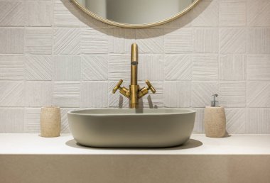 Bu şık banyo düzeneği modern bir lavabonun zarif bir pirinç musluk aksanıyla mükemmel bir şekilde eşleştirildiğini gösteriyor.