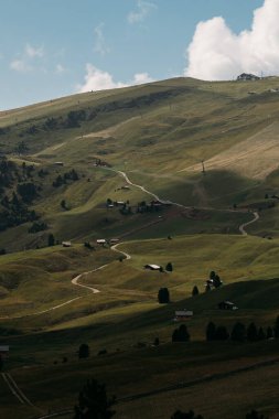 Görkemli Dolomitlerin nefes kesici manzarası sergiler yemyeşil tepeler, dolambaçlı manzaralı yollar ve resim gibi bir gökyüzü.