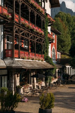 Scenic view of a beautifully adorned hotel in the Dolomites, showcasing architectural elegance and lush greenery. clipart