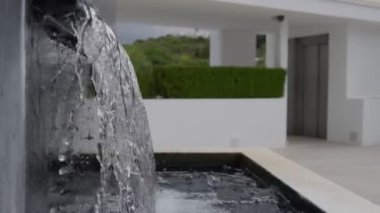 Modern mimari bir alana kusursuz bir şekilde entegre edilmiş şık ve görsel olarak çekici bir su özelliği.