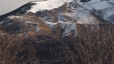 Nefes kesici bir kış manzarası sergileniyor çarpıcı karla kaplı dağlar ve güzel aydınlatılmış ağaçlar.