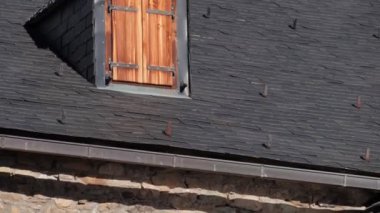 Kırsal çatılı, çarpıcı mimari detaylar ve katı taş duvarlara karşı işlenmiş ahşap panjurlar.