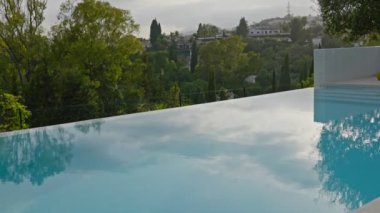 Çarpıcı bir sonsuzluk havuzu yumuşak renkleri zarifçe yansıtırken etrafındaki yemyeşil manzarayla pürüzsüz bir şekilde birleşiyor.