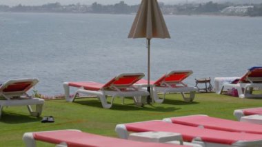 Huzurlu ve sakin bir rıhtım sahnesi dinlenmek için ideal dinlenme yerleri, bir şemsiye ve sakin su.