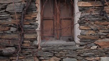 Eskimiş taş bir duvar, güzel yıpranmış bir pencereye sahiptir, tarih ve kırsal çekicilik duygusunu derinden çağrıştırır.