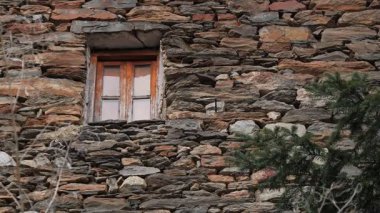 Eşsiz derecede büyüleyici ve güzel yıpranmış taş bir duvar. İçinde tuhaf, davetkar bir ahşap pencere var.