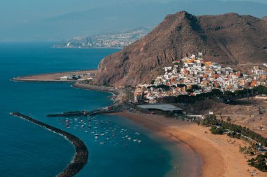 Tenerife 'de altın kumlu bir plajı, sakin bir denizi ve bir dağ zeminiyle manzaralı bir kasaba..