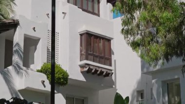 Canlı yeşilliklerle çevrili, ahşap balkonlu büyüleyici bir koloni tarzı bina sükuneti çağrıştırıyor.