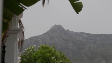 İspanya, Marbella 'daki görkemli La Concha Dağı' nın sakin ve sakin manzarası. Bulutlu bir gökyüzünün altında yemyeşil bir tepe güzel sarılmış.