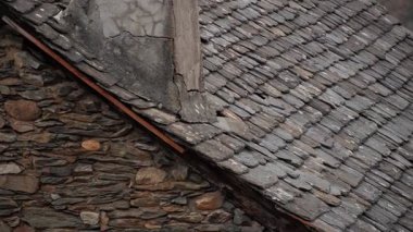 Güzel bir çatı ile birleşen, eşsiz dokular sergileyen, şömineli, taştan, büyüleyici bir duvarın yakın görüntüsü.