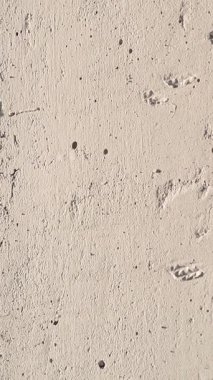 Ham beton bir duvarın yüksek detaylı görüntüsü, küçük delikleri, düzensizlikleri ve sert dokuyu vurguluyor..